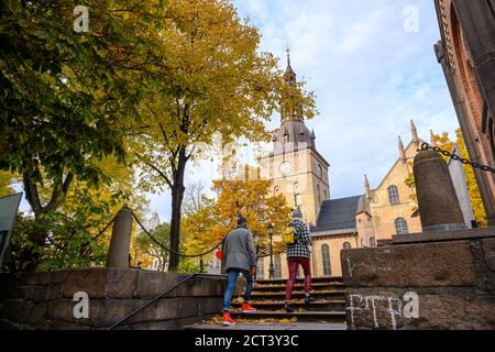 Due persone salgono le scale fino alla cattedrale di Oslo, situata nel centro di Oslo, Norvegia. In autunno, le foglie diventano gialle e arancioni. Foto Stock