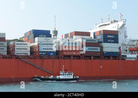 Barca pilota del porto Lufafa vela accanto alla nave container San Felix, Durban, Sud Africa, contiene loghi, carico, affari internazionali, trasporti Foto Stock