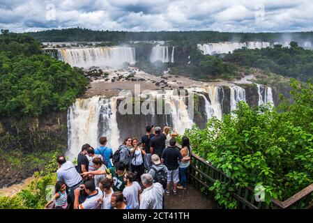 Turisti a Iguazu Falls (Cataratas del Iguacu) sulla piattaforma di osservazione lato brasiliano, Brasile Argentina confine con il Paraguay, Sud America Foto Stock