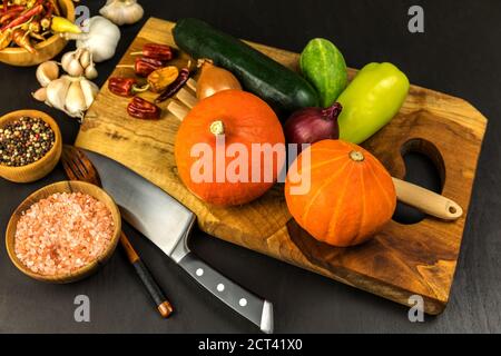 Zucca di hokkaido a fette su una tavola di legno. Preparazione fatta in casa della zuppa di zucca. Verdure fresche. Cibo sano. Foto Stock