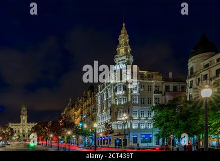 Porto, Portogallo - 30 maggio 2018: Vista notturna dell'edificio BBVA o dell'edificio Pinto Leite e del municipio con sentieri luminosi sull'Avenida dos Aliados Foto Stock