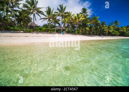 Acque cristalline dell'Oceano Pacifico e spiaggia di sabbia bianca tropicale con palme a Titikaveka, Rarotonga, sfondo delle Isole Cook con spazio per la copia Foto Stock