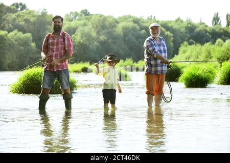 Nonno, padre e nipote che pescano insieme. Pesca. La famiglia della gente felice ha pesca e divertimento insieme. Pesca a mosca. Foto Stock