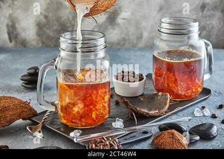 Caffè di ghiaccio tailandese con latte di cocco con ghiaccio tritato in un vasetto di Mason. Foto Stock