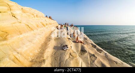 Foto panoramica della Scala dei Turchi, turisti che si rilassano al tramonto, capo Rossello, Realmonte, Agrigento, Sicilia, Italia, Europa Foto Stock