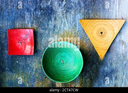 Piastre decorative di varie forme su vecchia parete testurizzata grunge Foto Stock