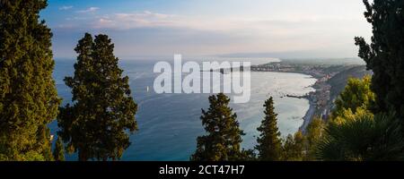 Taormina sulla costa siciliana al tramonto, foto panoramica della Baia di Naxos, con i piedi sul vulcano Etna sulla destra, Mar Ionio, Mar Mediterraneo, Sicilia, Italia, Europa Foto Stock