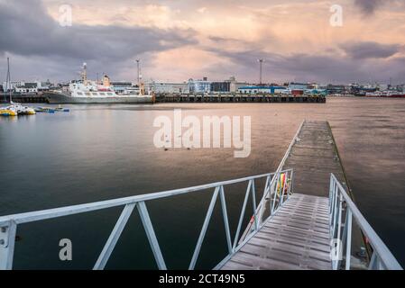 Porto e porto di Reykjavik all'alba sotto un cielo drammatico, Islanda, Europa Foto Stock