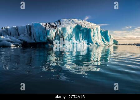 Splendido paesaggio islandese, con un iceberg nella laguna glaciale di Jokulsarlon, un lago glaciale che si fonde a causa del cambiamento climatico e del riscaldamento globale nel Sud-est dell'Islanda, in Europa Foto Stock