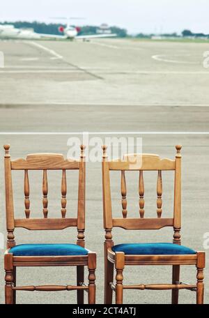 Due sedie di legno sull'aeroporto per VIP con privato offuscato getto in background Foto Stock