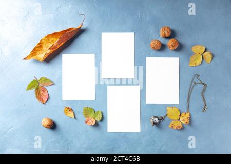 Mockup autunnale con cancelleria, top shot flatlay di quattro carte verticali A5 su sfondo blu Foto Stock