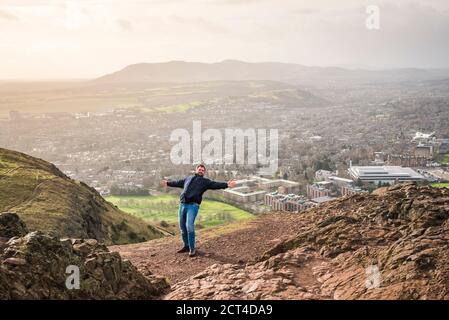 Essere soffiato dal vento su Arthur's Seat, Edimburgo, Scozia, Regno Unito, Europa Foto Stock