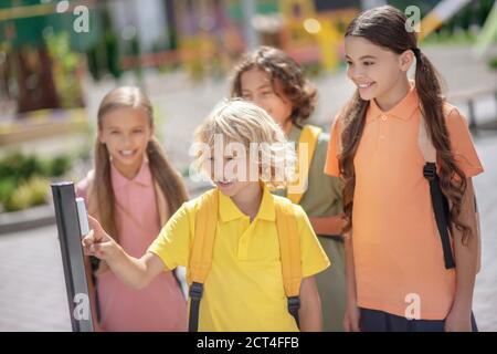 Gli studenti aprono il cancello mentre lasciano la scuola dopo le lezioni Foto Stock