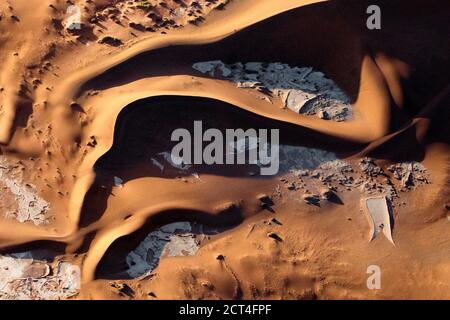 Astratto contrastato delle dune di sabbia rossa ricche di ossidi nel grande mare di sabbia della Namibia. Foto Stock