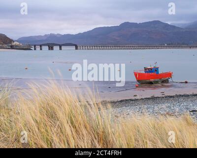 Vecchia barca da pesca e Barmouth Bridge nel porto di Barmouth con le montagne Cader (Cadair) dietro (parte del Parco Nazionale di Snowdonia), Gwynedd, Galles del Nord, Galles, Regno Unito, Europa Foto Stock