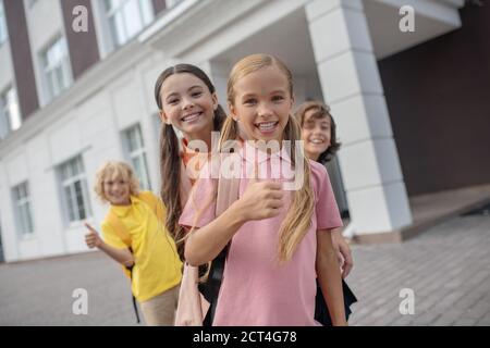 Scolari che giocano nel cortile della scuola e si sentono allegri Foto Stock