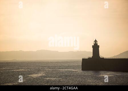 Faro di St Peter Port Harbour all'alba, Guernsey, Isole del canale, Regno Unito, sfondo stagape con spazio per la copia Foto Stock