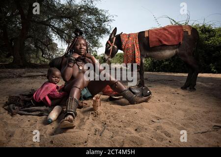 Una donna Himba si prepara in un letto di fiume, Namibia. Foto Stock