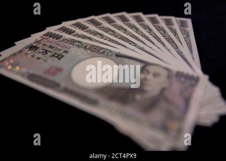 Valuta giapponese 100,000 yen su sfondo nero Foto Stock