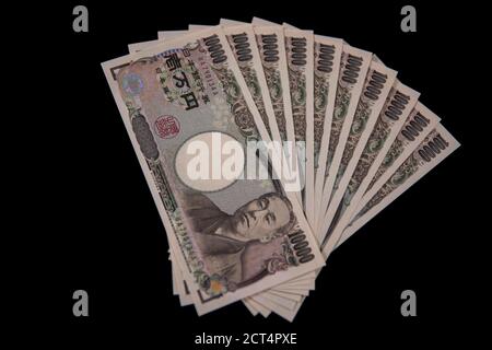 Valuta giapponese 100,000 yen su sfondo nero Foto Stock