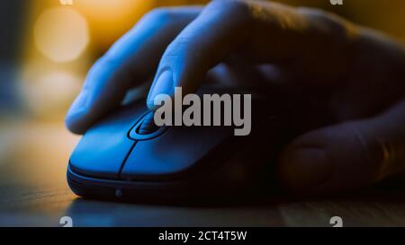 Primo piano Macro Shot: La mano della persona che usa il mouse del computer wireless, scorre attraverso le app e i siti web con una rotella e clic sui pulsanti. Nella Foto Stock