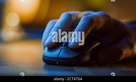 Primo piano Macro Shot: La mano della persona che usa il mouse del computer wireless, scorre attraverso le app e i siti web con una rotella e clic sui pulsanti. Nella Foto Stock