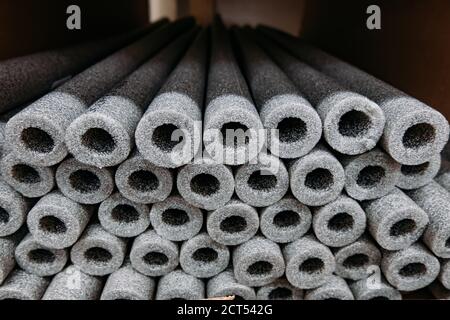 Isolamento impilato per tubi in polietilene espanso in magazzino. Foto Stock