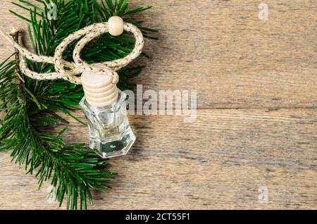 Profumo d'aria conifera in bottiglia di vetro con tappo di legno con rami di abete rosso su fondo di legno. Messa a fuoco selettiva. Foto Stock