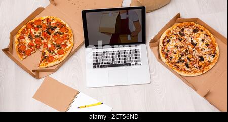concetto di ordine alimentare. Primo piano di una pizza ordinante con un computer portatile. Tutti gli schermi sono composti da grafica. Foto Stock