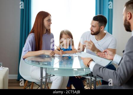 la giovane famiglia caucasica scusa la situazione, i problemi allo psicologo di famiglia. terapista professionale attentamente li ascolta, cerca di aiutare, dare consigli Foto Stock