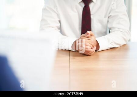 job seeker asiatico intervistato dal responsabile delle risorse umane in carica, concentrarsi sulle mani del candidato Foto Stock