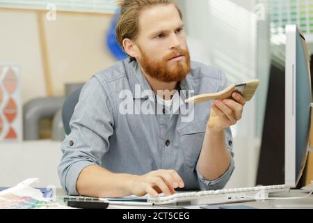 uomo d'affari che lavora con computer portatile e documenti al tavolo con calcolatrice Foto Stock