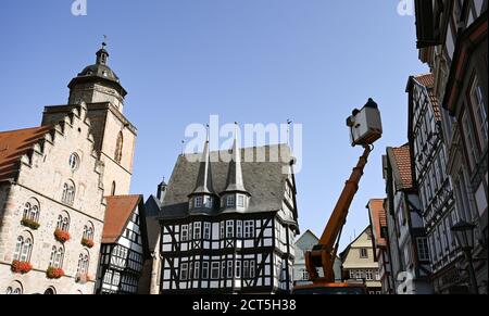 Alsfeld, Germania. 21 Settembre 2020. Elettricisti della città di Alsfeld sono in un riser vicino alla Walpurgiskirche (l) e il Vecchio Municipio (M) sul mercato della città a graticcio. Costruito tra il 1512 e il 1516, l'edificio è uno dei più importanti comuni tedeschi a graticcio. Credit: Arne Dedert/dpa/Alamy Live News Foto Stock