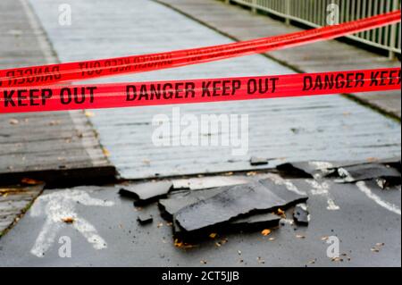 Nastro rosso che legge 'il tenersi fuori' che impedisce alle persone di attraversare un ponte. Preso in Christchurch dopo il terremoto che ha colpito il 22 febbraio 2011. Foto Stock