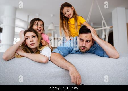 Madre stanca e padre, la coppia si sente seccata di bambini rumorosi Foto Stock