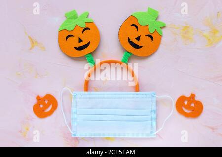 Concetto di Halloween Covid-19. Orecchie di zucca e maschera Foto Stock