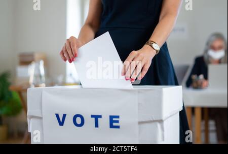 Donna irriconoscibile che ha messo il suo voto nel voto, negli stati uniti e nelle elezioni del coronavirus. Foto Stock