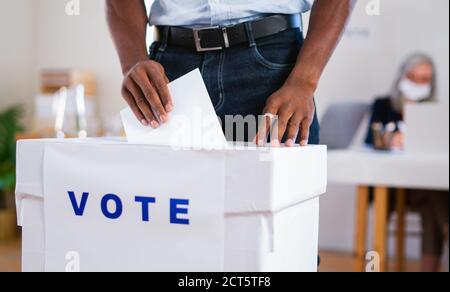 Irriconoscibile uomo afro-americano che ha messo il suo voto nel voto, elezioni usa e coronavirus. Foto Stock