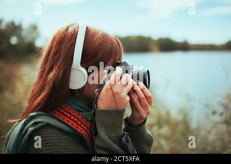 Giovane donna che scatta foto nella foresta con un vecchio fotocamera Foto Stock