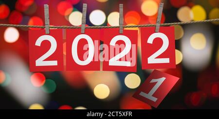 2022 Celebrazione di Capodanno su corda con i clothespins. Cifre su cartoncini rossi sullo sfondo festivo del bokeh. illustrazione 3d Foto Stock