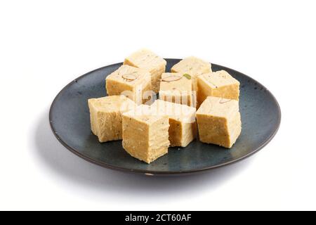 caramelle tradizionali indiane soan papdi in ceramica blu isolato su sfondo bianco. vista laterale, primo piano. Foto Stock