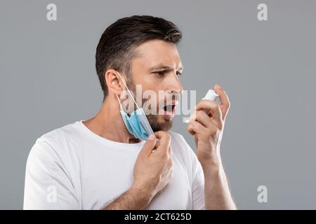 Ritratto dell'uomo con maschera protettiva con inalatore Foto Stock