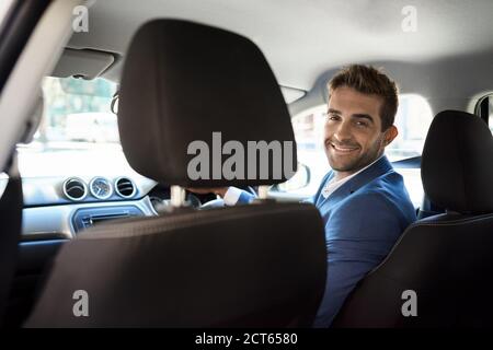 Autista cordiale che guarda le spalle e sorride Foto Stock