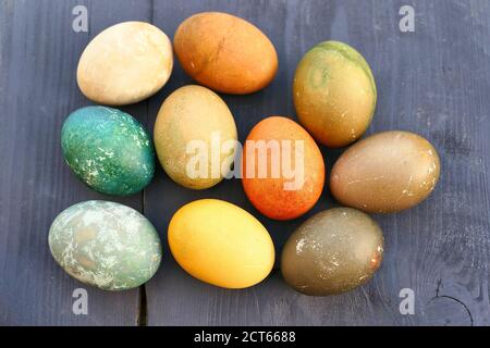 Uova di Pasqua tinte naturalmente su sfondo di legno. Foto Stock