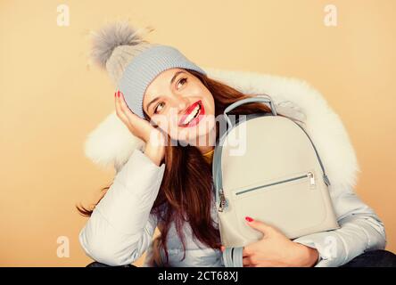 Giorno sognatore. donna in beanie hat con zaino. Felice vacanze invernali. ragazza in cappotto soffiato. Pelliccia di moda. influenza e della stagione fredda. Borsa in pelle alla moda. caldo abbigliamento invernale. shopping. Foto Stock