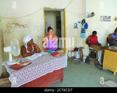 DUE DONNE E DUE UOMINI AL LAVORO IN UN CALZOLAIO Foto Stock