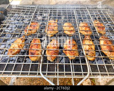 Delizioso pollo grigliato al barbecue. Ali di pollo sul mangal in natura. Picnic. Primo piano. Foto Stock
