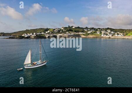 COVERACK, CORNOVAGLIA, REGNO UNITO - 12 SETTEMBRE 2020. Un'immagine aerea del paesaggio da drone di un lussuoso yacht a vela che si avvicina alla pittoresca pesca della Cornovaglia Foto Stock