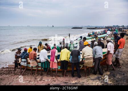 I pescatori portando le loro barche da pesca a Negombo mercato del pesce (Lellama mercato del pesce), Negombo, sulla costa occidentale dello Sri Lanka, in Asia Foto Stock