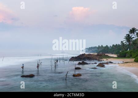 Stilt pesca, stilt pescatori a Midigama Beach, vicino Weligama, South Coast, Sri Lanka, Asia Foto Stock